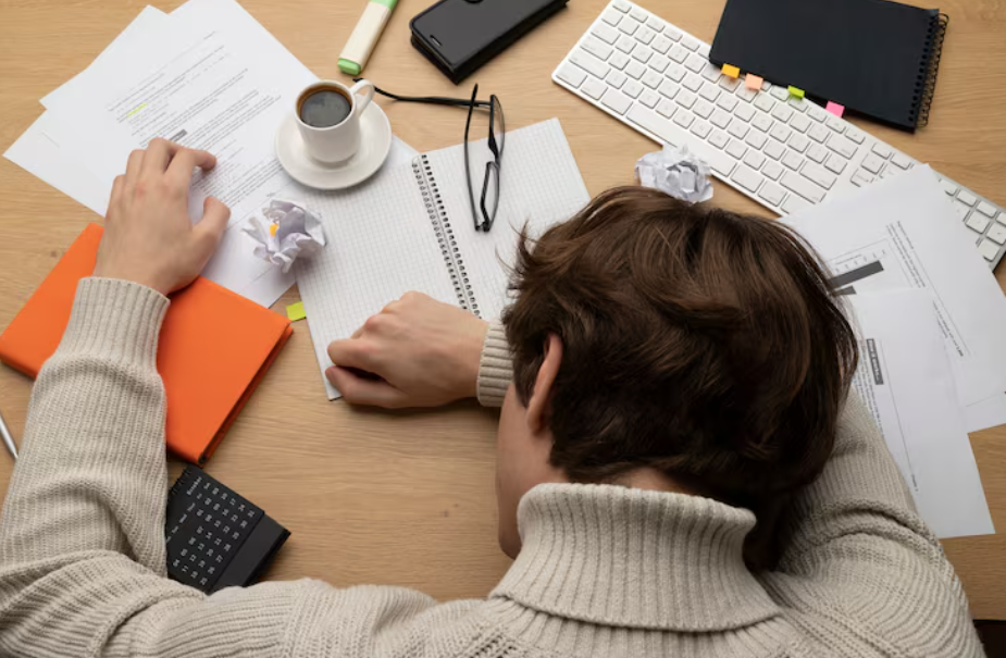 Student asleep on messy desk, illustrating procrastination and burnout.