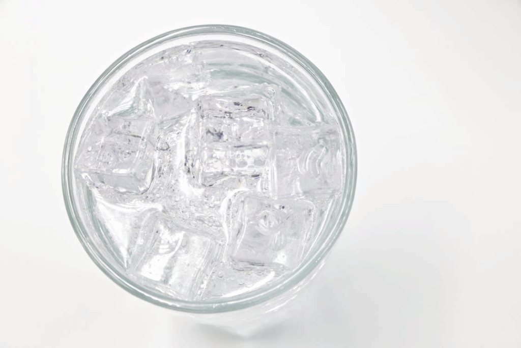 Ice cubes floating in a glass of water, showing why ice floats due to lower density