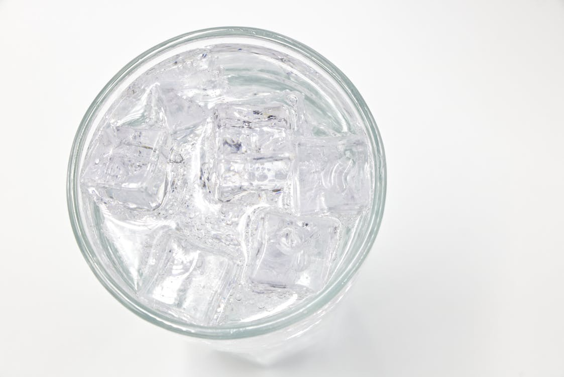 Ice cubes floating in a glass of water, showing why ice floats due to lower density