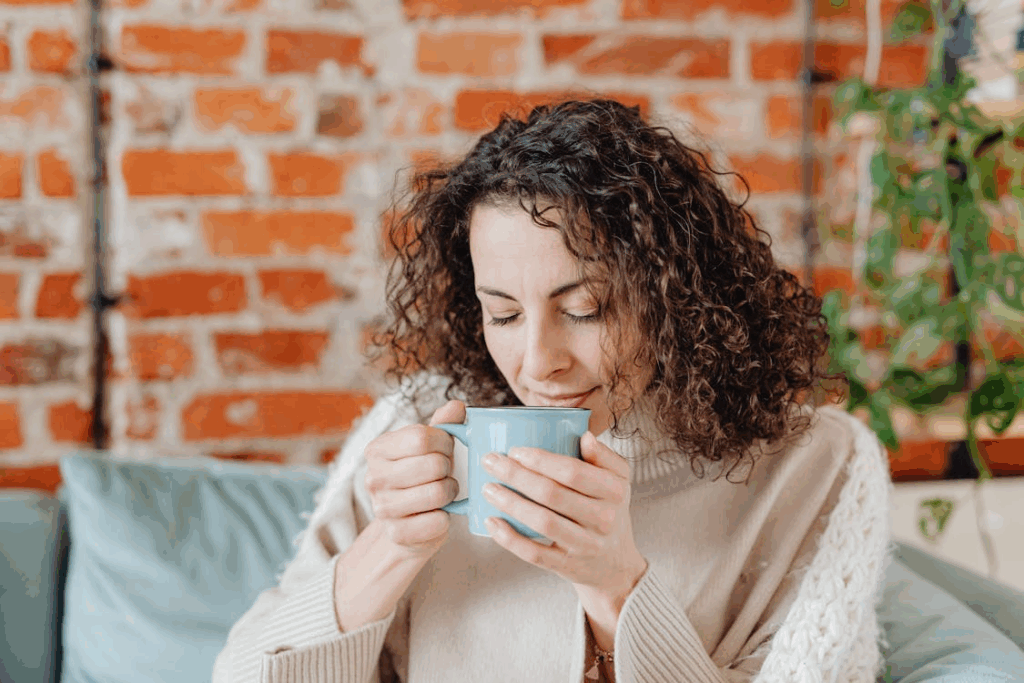 Close-up of a woman savoring a drink’s aroma, illustrating scent-evoked nostalgia.