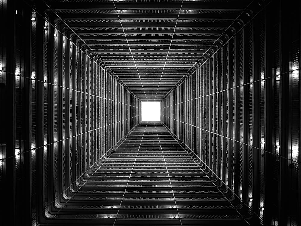 Black-and-white atrium looking straight up, creating a vanishing point optical illusion.